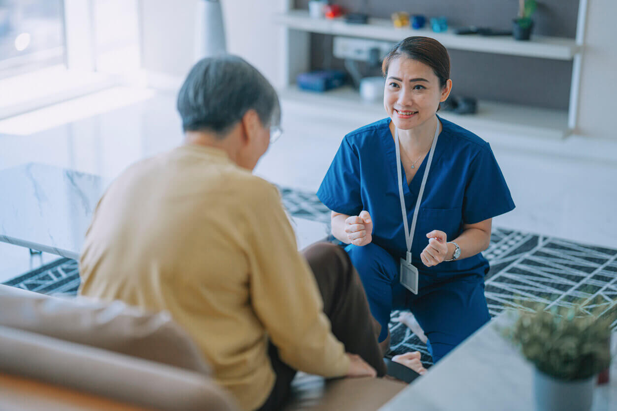 contract physical therapist encouraging senior woman exercising with her legs cycling