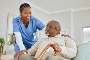 Home health aid speaking to her male patient at his house